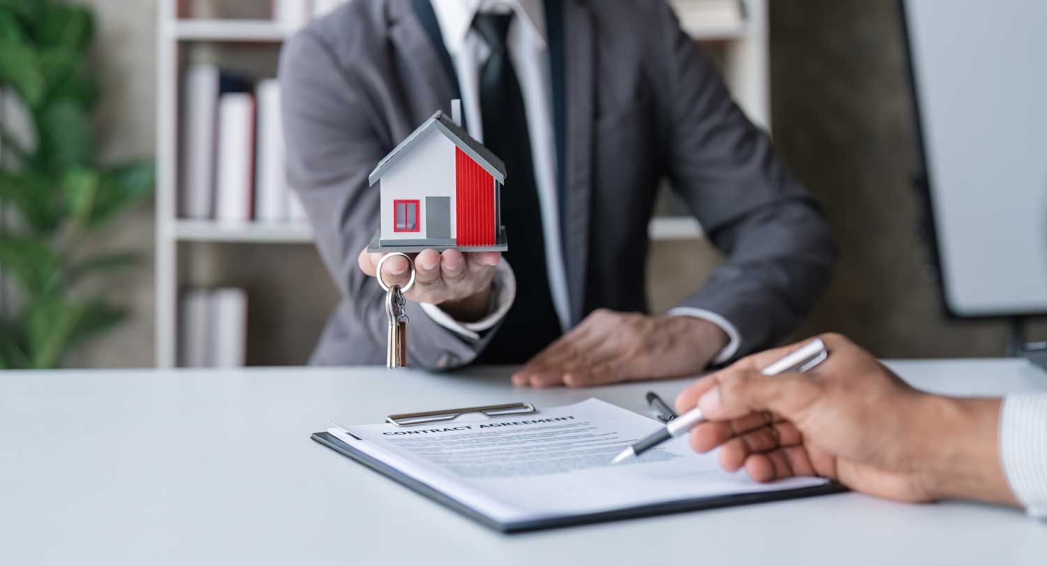 Client consultation at SKB Law Firm, with a house model on table, symbolizing real estate law expertise.