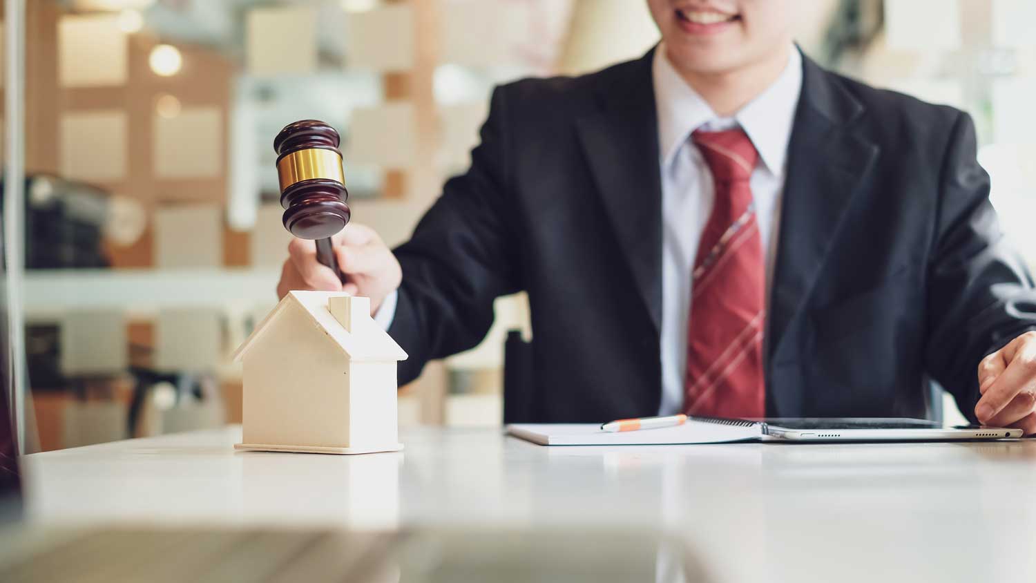 A man in suit and tie holding a gavel.